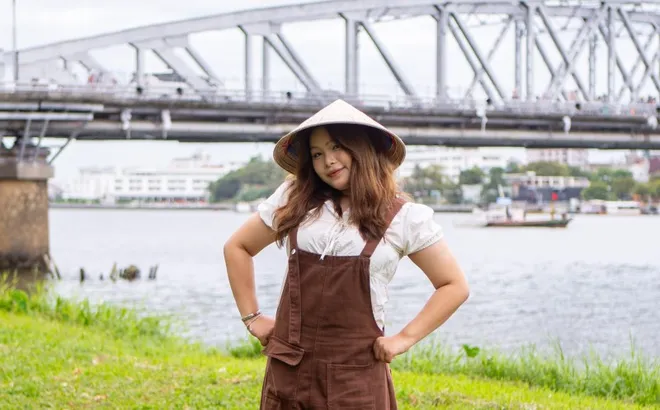 Đội mưa chụp ảnh tại bãi cỏ 'nàng thơ' ven sông Hương ở Huế